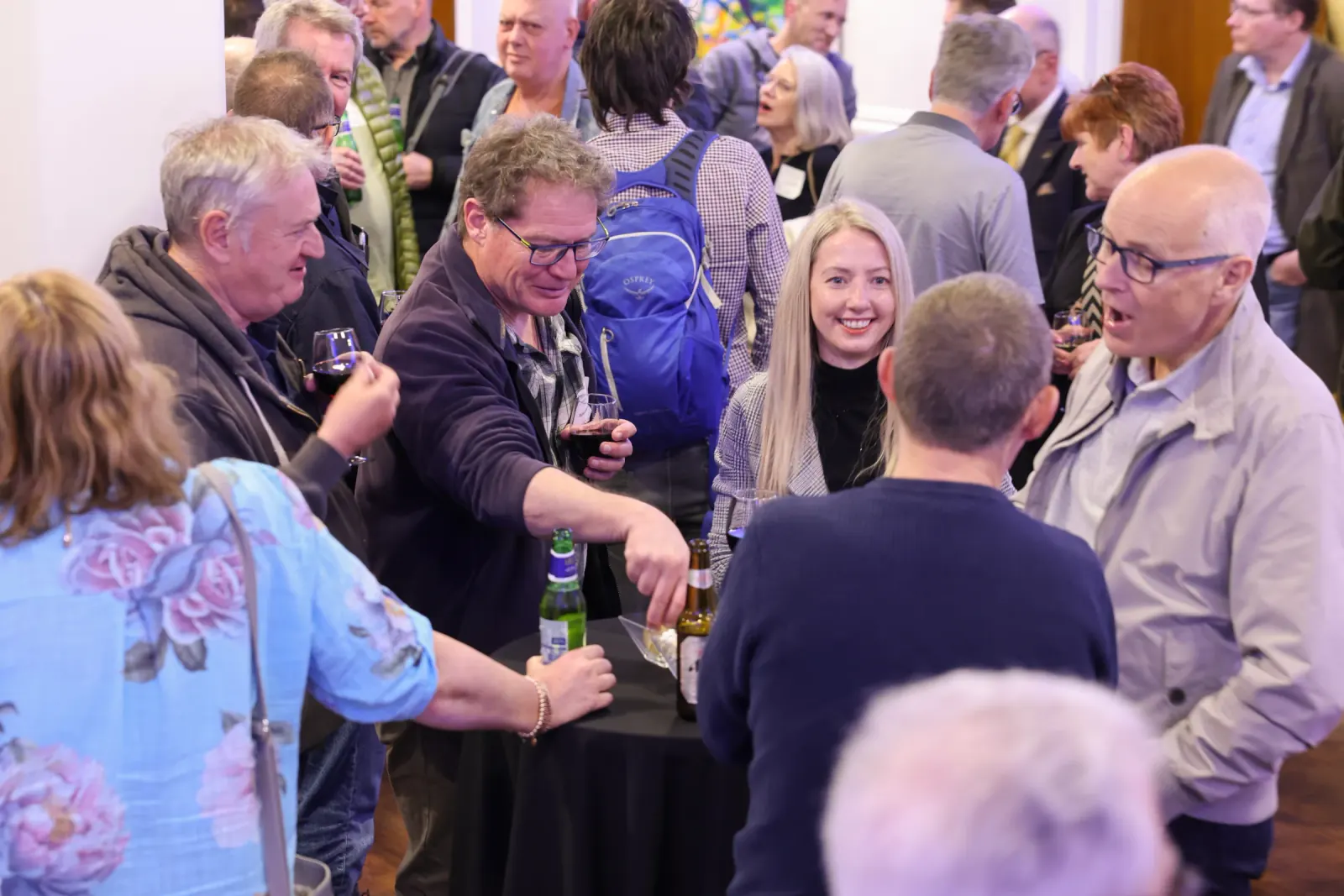 Guests at the Greatland Resources drinks reception, standing around a high table with wine and beer